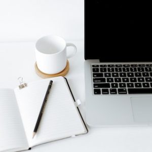 ordinateur-tasse-a-cafe-blanche-cahier-crayon-noir-sur-fond-blanc
